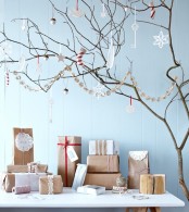 branches with paper and felt ornaments and a garland plus gift boxes wrapped in kraft paper