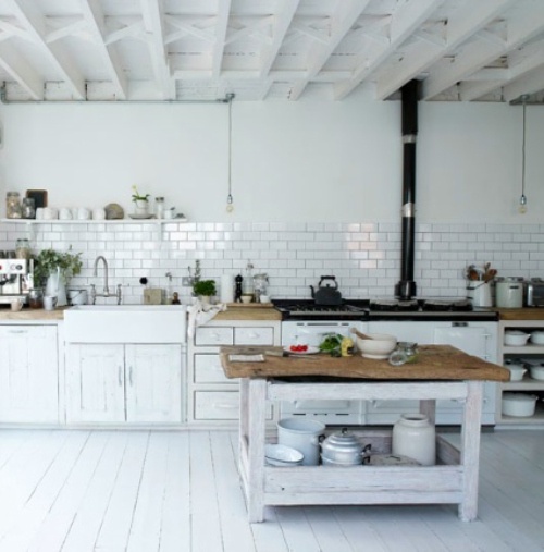 a white Nordic kitchen with white cabinets, a whitewashed kitchen island, a vintage stove and all white surfaces