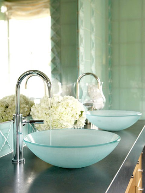 a sink space with two aqua vessel sinks of glass and soem white hydrangeas