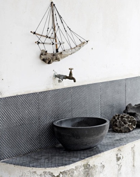 a wabi-sabi bathroom with a shabby chic vanity, black and white tiles, a concrete vessel sink and a branch ship art