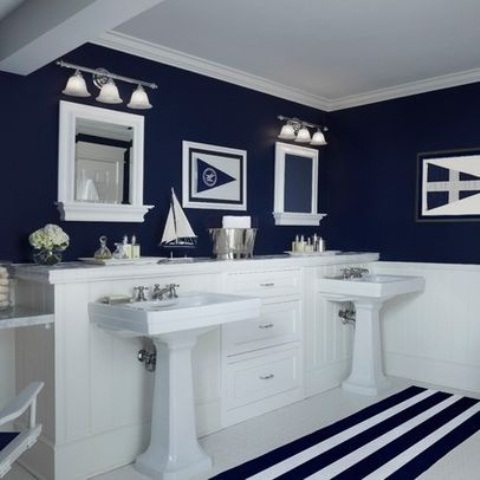 a nautical navy and white bathroom with stripes, mirrors and boat and ship decorations