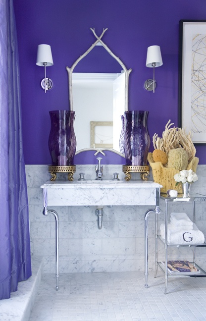 a purple and marble tile bathroom with sponges and corals, with a catchy mirror and large purple lanterns