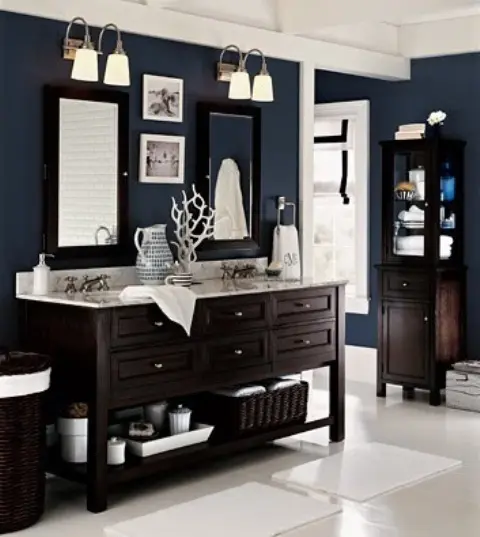 a navy sea bathroom with dark-stained furniture, dark baskets and some white surfaces to create a contrast