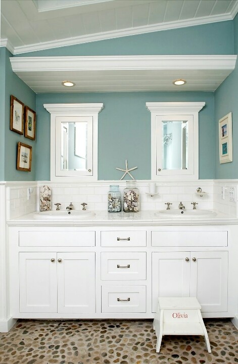 slate blue and white bathroom with a large white vanity, artworks and starfish and seashells