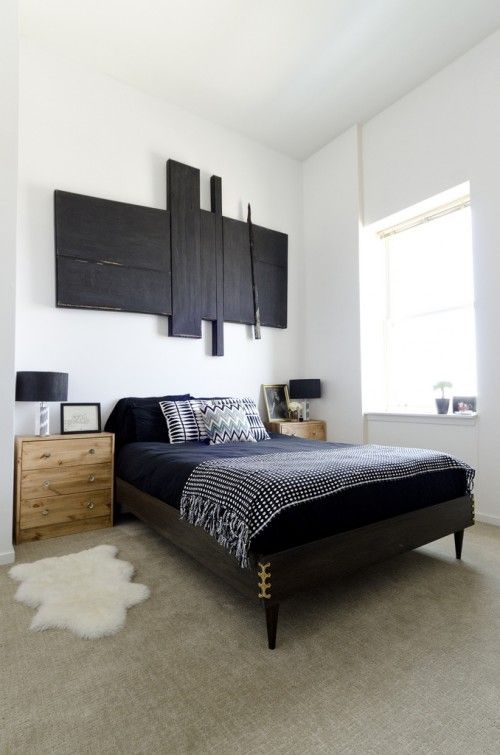 A black wooden mid century modern bed and light stained nightstands for a bold mid century modern bedroom