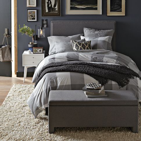 A light grey upholstered bed and a matching chest for storage will make your mid century modern bedroom welcoming