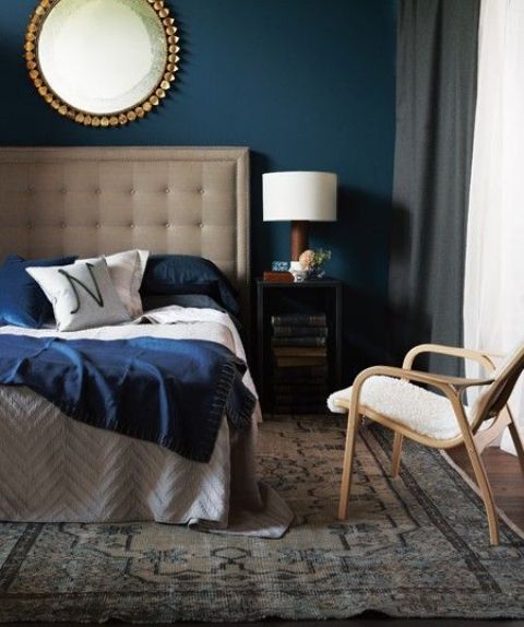 A neutral bed with an oversized upholstered tufted headboard and grey box nightstands for a bold and cool mid century modern look