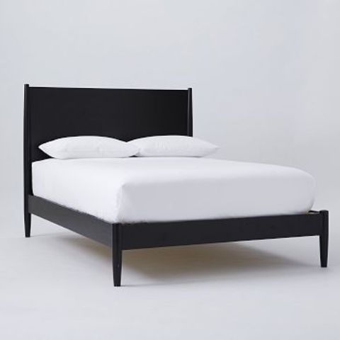 A very simple black mid century modern bed with a laconic curved headboard is a stylish piece for a mid century modern bedroom
