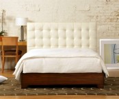 a rich stained wooden bed with a white leather tufted headboard looks chic and refined and will make a statement in a mid-century modern room