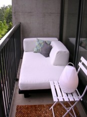 a small balcony finished off with elegant modern furniture – a sofa and a folding chair – is a great nook to spend some time in