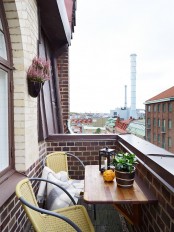 a small balcony with a folding table and a couple of chairs with potted greenery is a lovely space to have breakfast in