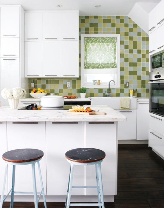 a small white kitchen with sleek cabinets, white stone countertops and a bright green tile backsplash is fun and cool