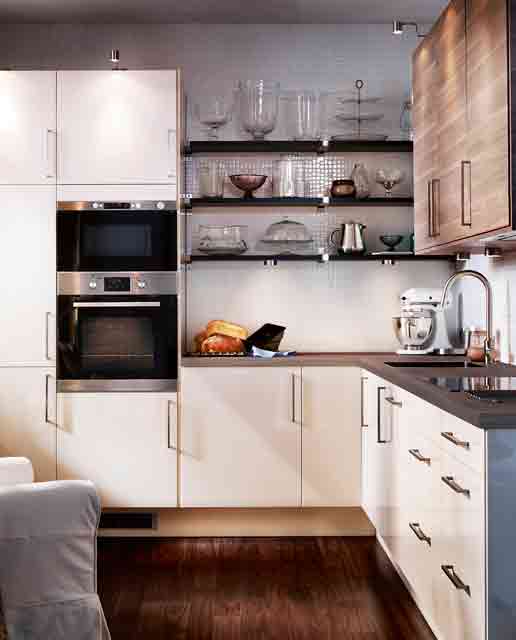 A small white kitchen with dark stained countertops, dark stained shelves and built in appliances is amazing