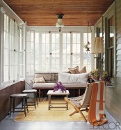 a retro-inspired sunroom with wooden and wicker furniture, lamps and lights and touches of color