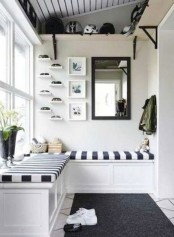 a monochromatic space with a striped built-in bench, a rug and some shelves for storage