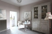 a whitewashed storage cupboard is a statement piece in this vintage and chic whitewashed room