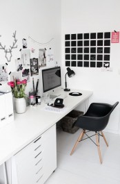 a white Scandinavian home office with a white desk, a black chair, a gallery wall and a chalkboard for planning days and for leaving memos