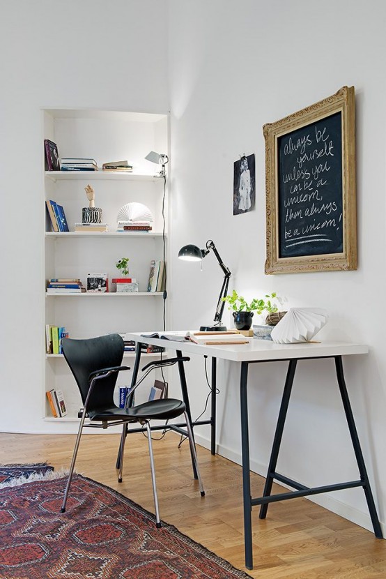 a stylish Scandi working space with built-in shelves, a white desk, a black leather chair and a framed chalkboard is a lovely space to work in