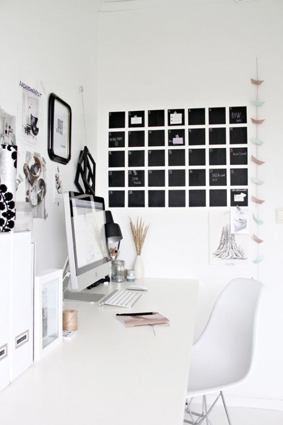 a Scandinavian home office with a white desk and a chair, a gallery wall and a chalkboard schedule that helps planning each day