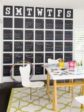 a cool home office with a white desk and a white chair, a colorful rug and a chalkboard schedule plus colorful supplies is a lovely space to be in