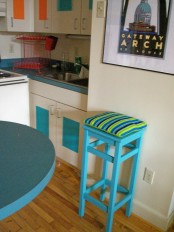 an IKEA Oddvar stool with added height, painted turquoise and with bright upholstery