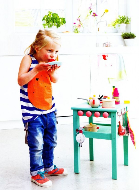 a bright kids' kitchen made of an IKEA Oddvar stool painted emerald and redone with hooks and other accessories
