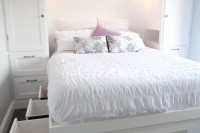 a white built-in bed with storage drawers in the sides of the bed is a cool idea to go for