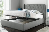 a grey upholstered bed that can be raised to place some things inside it is a cool piece to rock