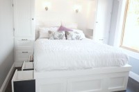 a built-in white bed with storage drawers in the sides of the bed is a cool solution and storage units on both sides of it will add storage space