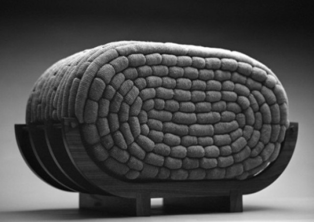 A creative curved seat with a crocheted filled is a very catchy and non typical furniture piece