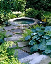 an outdoor bathtub or jacuzzi clad with stones around will be your personal spa and relaxation oasis