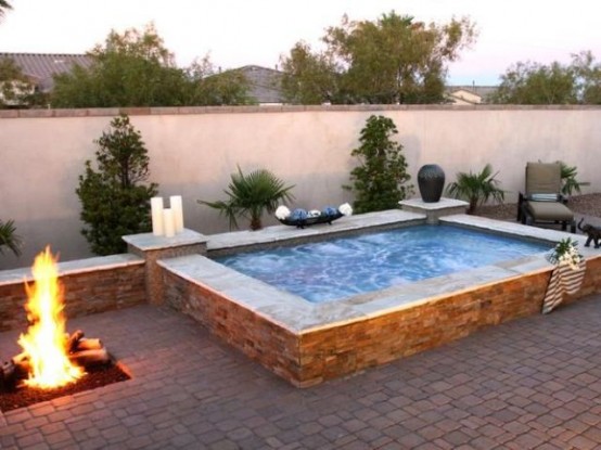 a large outdoor jacuzzi with candles and a fire pit next to it is relaxation with two elements - fire and water