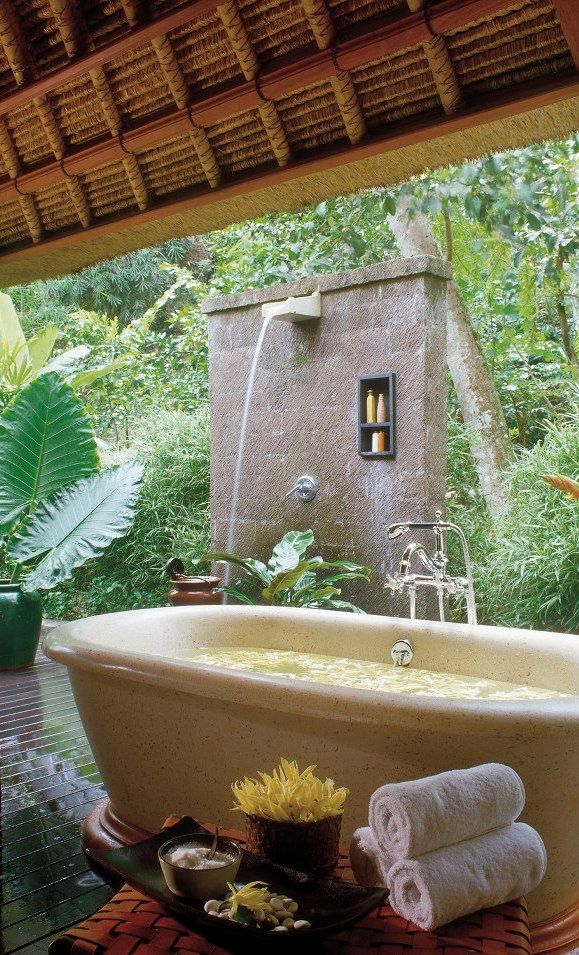 An outdoor waterfall shower and a stone bathtub next to it   you can choose your experience each time you want