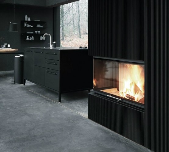 a stylish modern black kitchen with open shelves, a matte metal kitchen island, a fireplace and a glazed wall for more air and light in the space