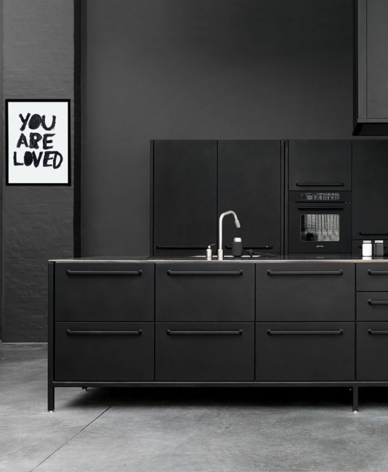 a matte black kitchen with sleek metal cabinets and a kitchen island, matte graphite grey walls and an artwork