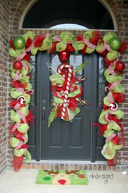 a garland of green and red mesh to cover the door line and a decoration with ribbons and a candy cane on the door