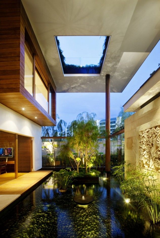 A whole water garden indoors   with a pond, lots of plants, artworks and some lights to accent it is a very zen space