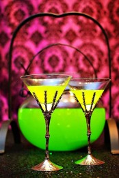 neon green Halloween drinks in glasses holded by skeleton hands – yes, please