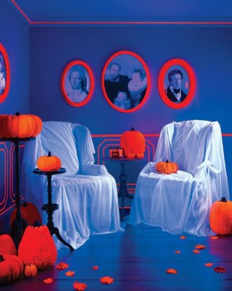 Neon orange pumpkins and portraits in neon orange frames accent the space and make it Halloween like instantly