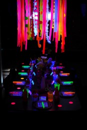 a modern and bright Halloween party space with a neon chandelier, glasses, menus and lights is awesome and very inspiring