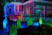 a mini graveyard in front of the house with neon lights is a great idea to style your outdoor space for Halloween