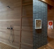 a sleek bathroom with a wood clad wall, a ladder, a wooden slab floor is a cool idea for a contemporary space