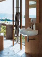 a bathroom with a view, with a wooden ladder, wood clad walls, a sink, a mirror cabinet in a wooden frame and a wooden stool