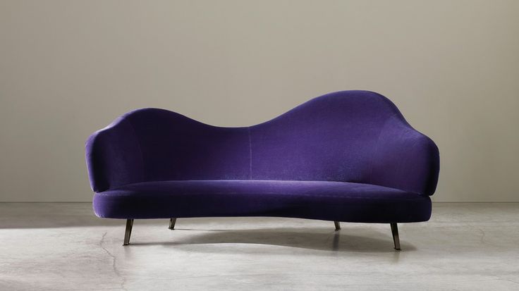 A bold violet sofa with a curved back is a stylish and catchy idea with plenty of color that will make a statement in your room