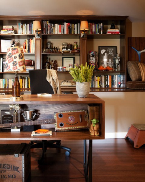 A mid century modern home office with rich stained wooden furniture, a desk with storage, lamps and potted greenery