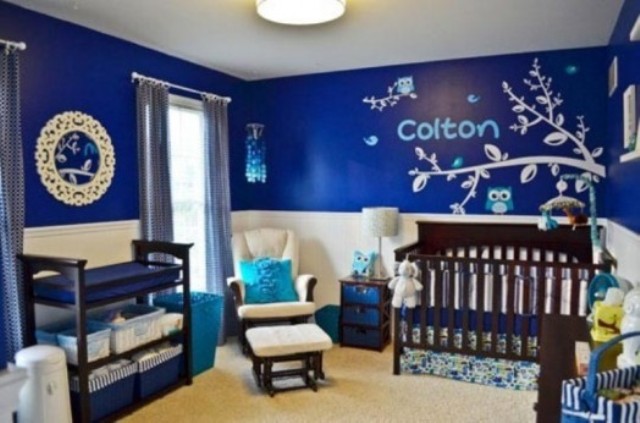 a bold blue and white boy's nursery with paneling on the walls, dark stained furniture, printed and bold textiles is a stylish idea