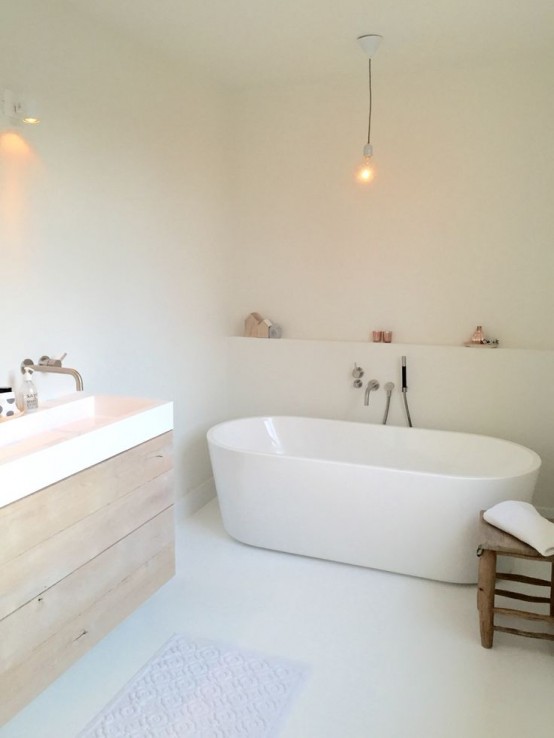 a white minimalist bathroom with sleek walls, a wooden floating vanity, white appliances, simple lights and accessories