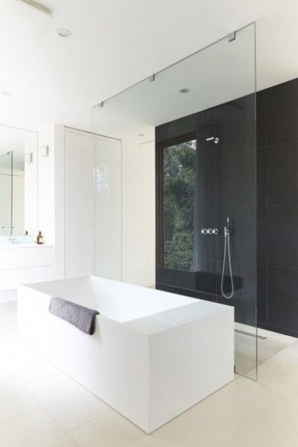 a minimalist bathroom with a black accent wall and all-white everything, white appliances and furniture
