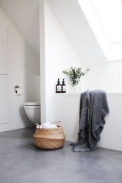 a minimalist attic bathroom with white walls and a ceiling, with a grey concrete floor, windows and white appliances