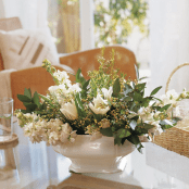 a vintage white porcelain bowl with fresh white blooms and greenery for decorating a coffee table